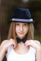 Young girl in a hat and bow tie
