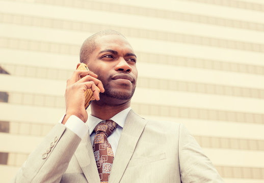 handsome happy young businessman talking on mobile phone