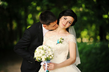 groom kisses on the neck bride