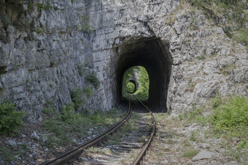 Schienen führen in zwei hintereinander liegende Eisenbahn Tunnel in einer Felswand in den Südkarpaten mit einem Zug Gleis 