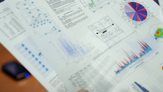 Analyst stapling several pages of the documents 