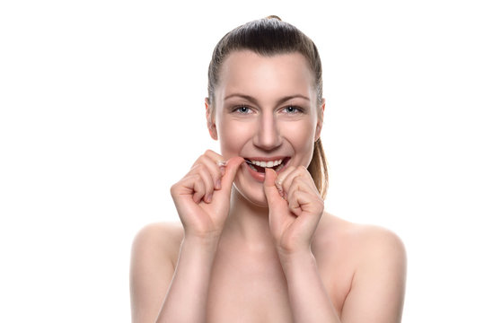 Lächelnde nackte Frau mit Zahnseide