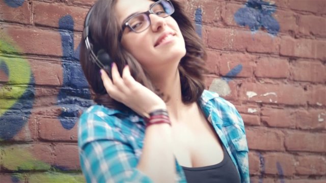 Woman wearing headphones listening to music and having fun