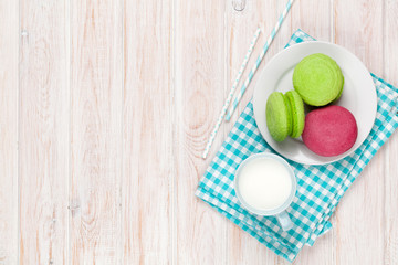 Colorful macarons and cup of milk