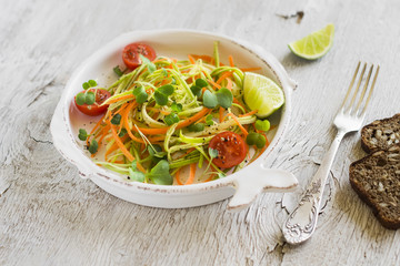fresh salad with zucchini and carrots in a vintage plate 