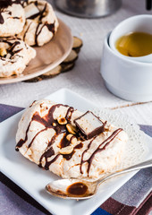 vanilla meringue with chocolate, caramel and nuts, sweet cake, a
