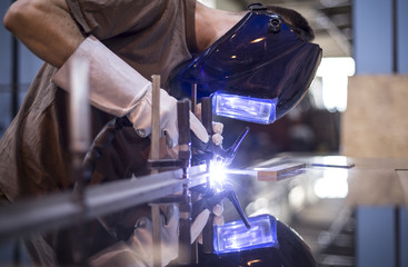 Fototapeta Employee welding stainless steel using welder machine obraz