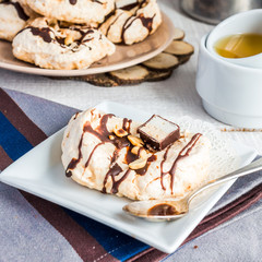 vanilla meringue with chocolate, caramel and nuts, sweet cake, a