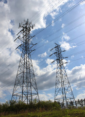 Two Giant Transmission Towers Standing Against Sky
