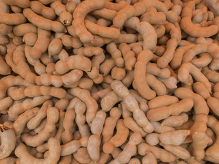 Pile of Sweet tamarind on wood plank Background Texture