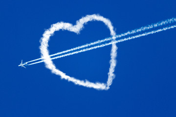 Naklejka premium aircraft at the blue sky flying through the heart of the clouds