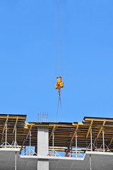 Crane and building construction site against blue sky