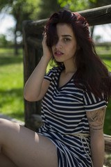 Sunny, sexy girl with long red hair in a park in summer