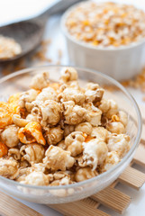 A bowl of popcorn on a wooden table, caramel popcorn