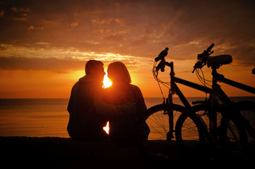 Fototapeta na wymiar Couple of cyclists at the beach at sunset.