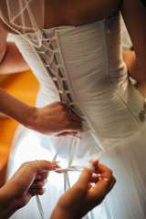 beautiful bride getting ready in white wedding dress with