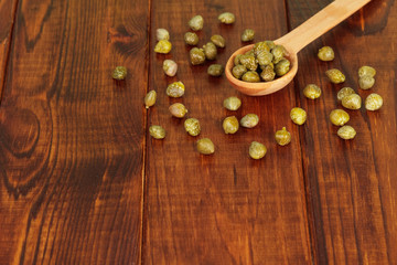Green capers in spoon