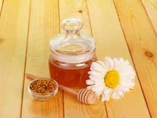 Fototapeta na wymiar Honey jar with dipper and flower