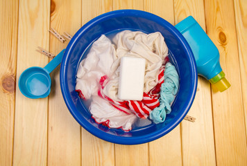 Dirty laundry in blue bowl with soap