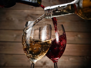 Red and wihite wine pour on wood background
