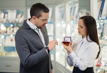 Man with assistant help choosing jewellery