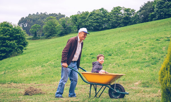 Senior man raking hay with pitchfork on field