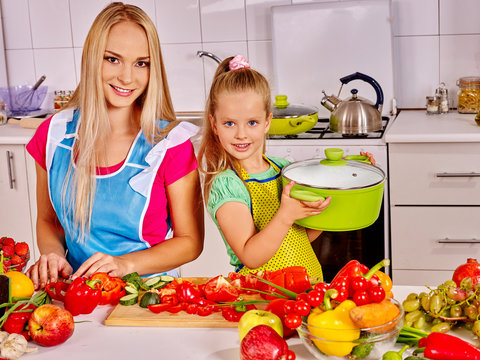 Mother and daughter cooking at kitchen.