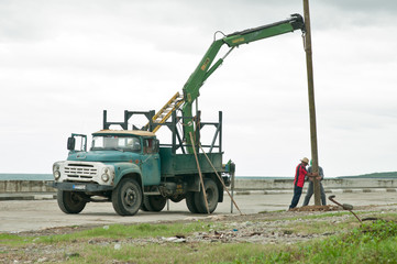Mit Oldtimer-LKW wird ein Masten in Kuba, Baracoa, aufgestellt