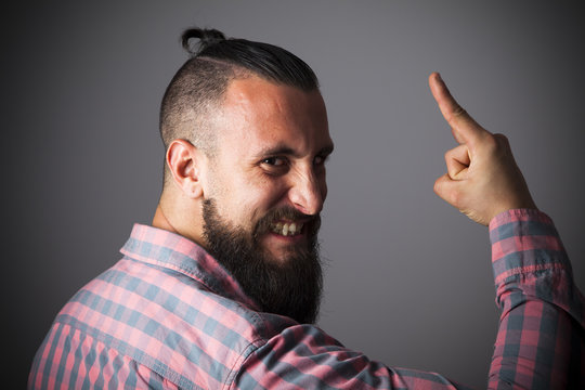 Joven con barba y camisa a cuadros haciendo cuernos