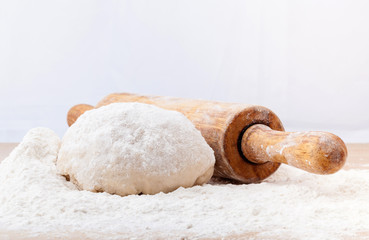 Baking ingredients  flour and a rolling pin on wooden table.