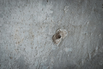 Drilled hole in a grey concrete wall