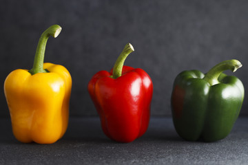 Three bell peppers on Indian Limestone surface.