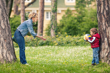 Cute little boy throwing a ball to his mother