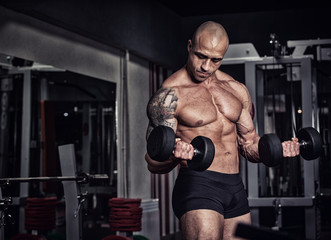 Fototapeta na wymiar Closeup of a muscular young man lifting weights. Fine art.