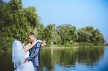 Married couple kissing on river beach. Bride Groom  couple