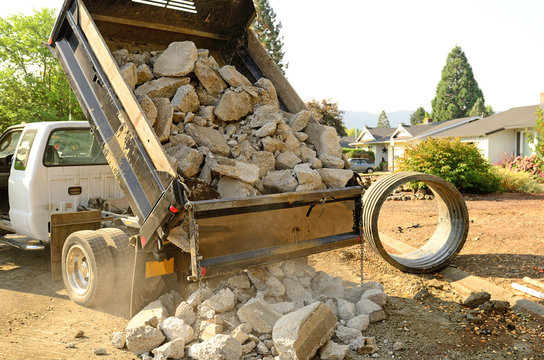 A Small Dump Truck Dumps Concrete Pieces 