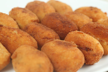 Croquetas de jamón servidas en un plato blanco.