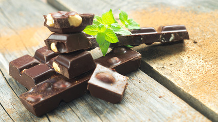 Stack of chocolate slices with mint leaf on the wooden surface