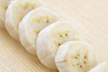 yellow banana in bunch and slice on wood