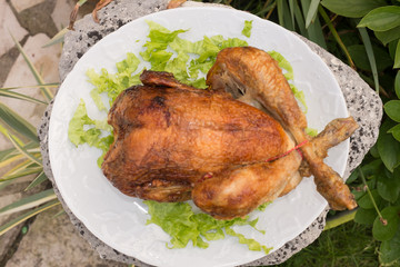 Whole roasted chicken with salad  on white plate