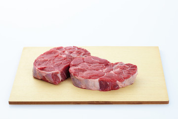 Fresh steak with spices on wooden background