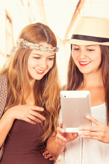 Beautiful young trendy girls using tablet
