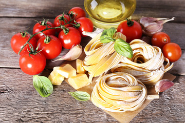 Pasta with cherry tomatoes and other ingredients on wooden table background