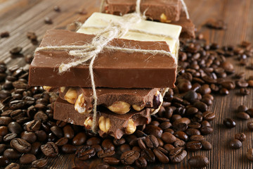 Stack of tied chocolate with coffee beans on wooden table, closeup
