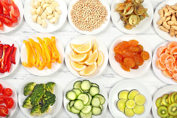 Different products on saucers on wooden table, top view