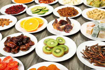 Different products on saucers on wooden table, closeup