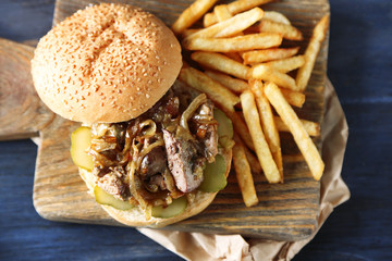 Tasty burger and french fries on wooden table background , close-up Unhealthy food concept