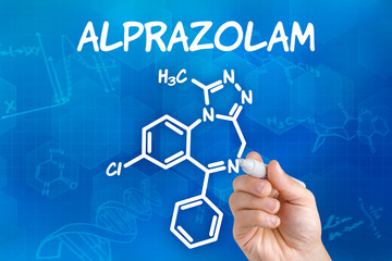 Hand mit Stift zeichnet chemische Strukturformel von Alprazolam
