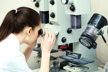Female scientist looking through a microscope in laboratory