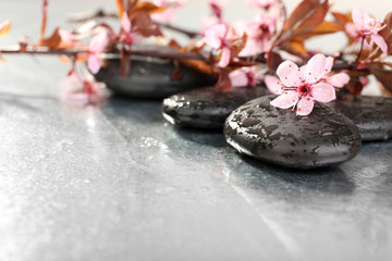 Spa stones with spring flowers on table close up